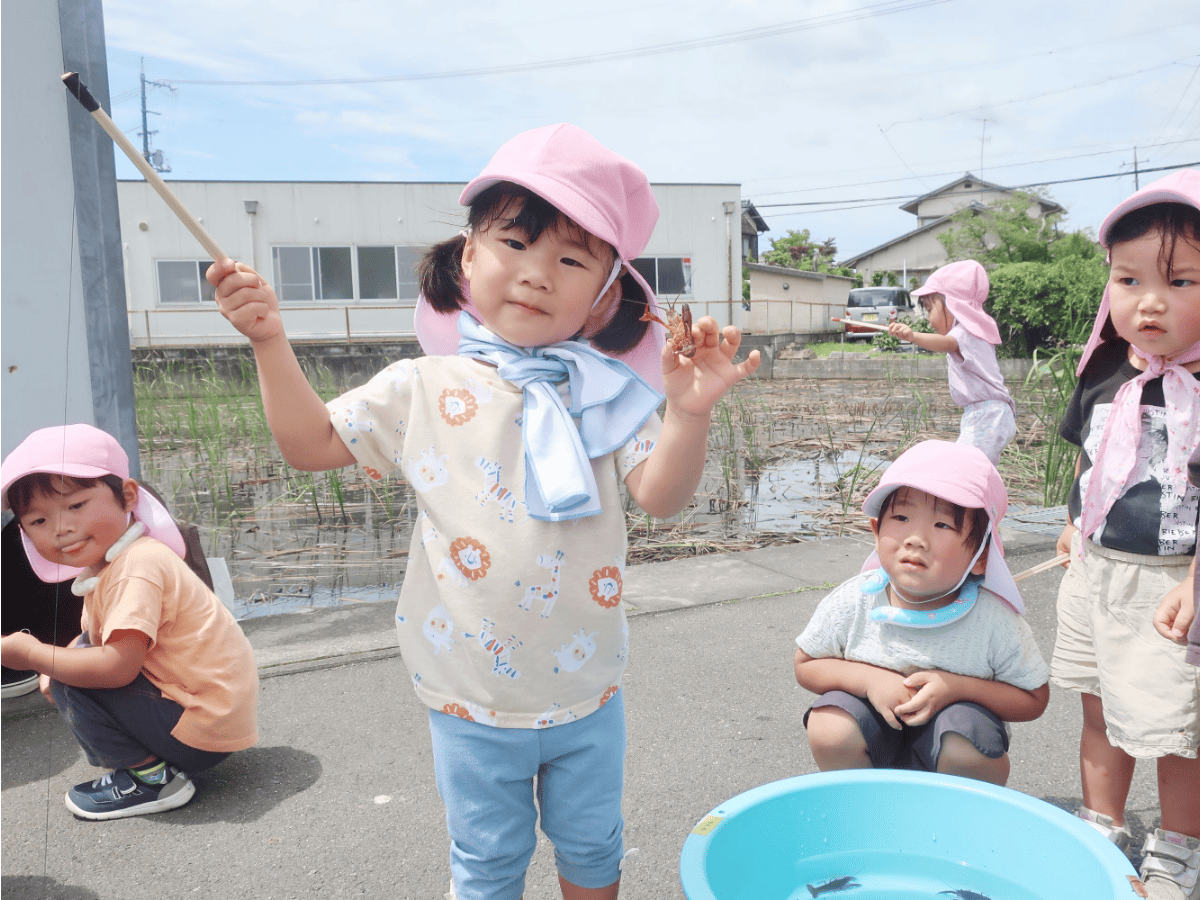 ザリガニ釣りをする園児たち