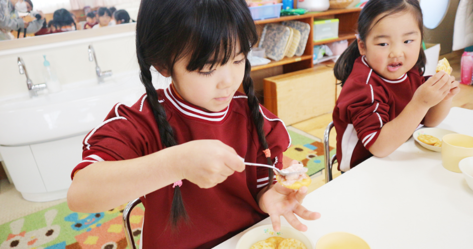 お昼のおやつを食べる園児たち